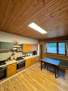 a kitchen with wooden cabinets and a blue table at Haus Schönblick in Tannheim