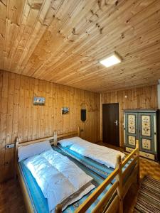 a bedroom with two beds in a wooden cabin at Haus Schönblick in Tannheim