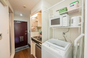 東京にあるsakura 606のシンクと電子レンジのある小さなキッチン