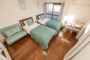 東京にあるsakura 606のベッド2台、椅子、テーブルが備わる客室です。