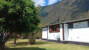 a white house with a mountain in the background at La Caz'Anna in Cilaos