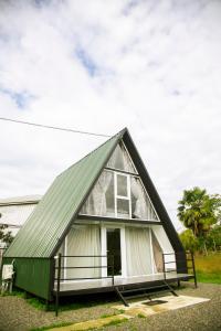 a small house with a green roof at Cozy cottage with mountain view in K'obulet'i