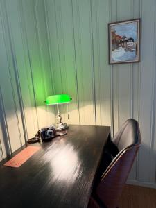 a table with a green lamp and a camera on it at Private pearl in downtown Røros in Røros