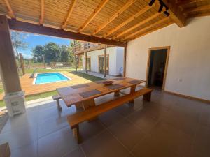 a dining room with a table and a pool at Suíte no Rancho Minas in Porto Seguro