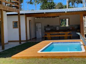 a backyard with a swimming pool and a house at Suíte no Rancho Minas in Porto Seguro