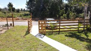 a wooden fence on the side of a road at Suíte no Rancho Minas in Porto Seguro