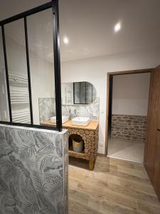 ein Badezimmer mit Waschbecken und Spiegel in der Unterkunft Gîte Les Aubracs - Puy de Dôme - Massif du Sancy in Saurier