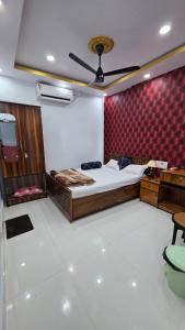 a bedroom with a bed and a red wall at Meera Hotel And Lodging in Badarpur