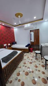 a bedroom with a bed and two chairs and a table at Meera Hotel And Lodging in Badarpur