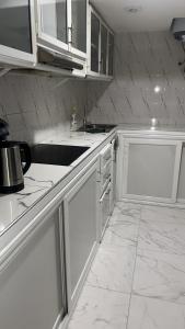 a white kitchen with white cabinets and a sink at Ramela in Dakar