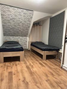 a room with two beds and a brick wall at Penzion Bilina in Teplice