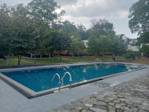a swimming pool with two faucets in a yard at Seeing Green Udawalawa in Udawalawe