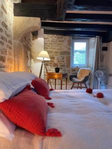 a bedroom with a large bed with red pillows on it at La Closerie de Gigny Maison Templiere avec Piscine,jacuzzi in Gigny