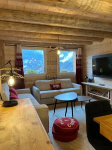 una sala de estar con un sofá y una mesa en Chalet des balcons, en Saint-Michel-de-Maurienne