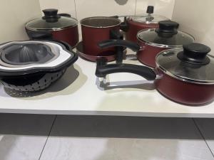 un groupe de casseroles et poêles sur un comptoir dans l'établissement Yes João & Maria Casa inteira com garagem 7km aeroporto GRU, à Guarulhos