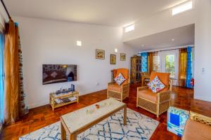 a living room with two chairs and a table at Casa Maravilha III in Caniço