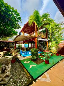 ein Resort mit einem grünen Garten mit Palmen in der Unterkunft Villas Ela Bahía Ballena Uvita hermosas habitaciones privadas grandes, piscina, cocina, jacuzzi, aire acondicionado, tv y baño privado in Uvita