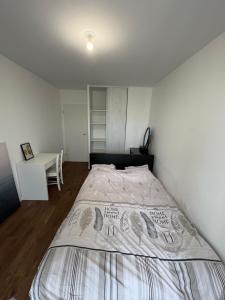 ein Schlafzimmer mit einem großen Bett in einem Zimmer in der Unterkunft Chambre cozy avec lit double en étage in Bois-Colombes
