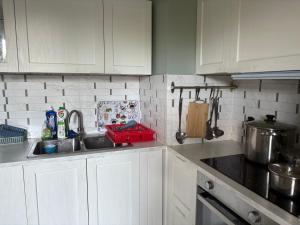 eine Küche mit weißen Schränken und einer Spüle in der Unterkunft Chambre cozy avec lit double en étage in Bois-Colombes