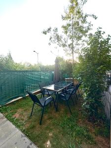 einen Tisch und Stühle mit Sonnenschirm im Hof in der Unterkunft Chambre cozy avec lit double en étage in Bois-Colombes