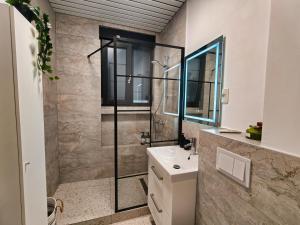 a bathroom with a sink and a glass shower at Piata Romana Suites & apartments - Pumo Properties in Bucharest +16 photos