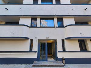 a white building with a blue door at Piata Romana Suites & apartments - Pumo Properties in Bucharest