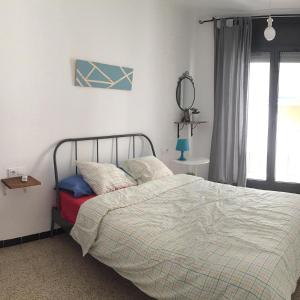 una camera da letto con un letto e uno specchio sul muro di Villa Llanca Dominiq a Llança