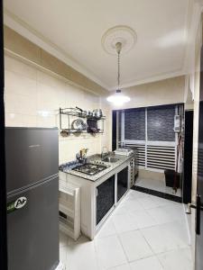 a kitchen with a stove and a refrigerator at appartement bien situé a SALAM in Agadir