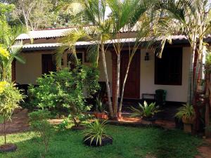 a house with palm trees in front of it at Green Lake Sigiriya in Sigiriya