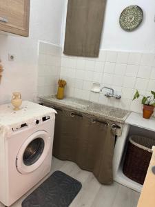 a kitchen with a washing machine and a sink at Traditional Villa Stella in Archangelos +1 photo