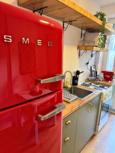 a red refrigerator in a kitchen with a sink at Meet Prishtina Apartments in Pristina