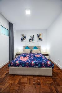 Un dormitorio con una cama con una colcha floral. en Sea Breeze I, en Caniço