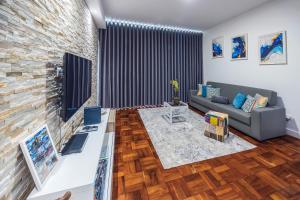 Una sala de estar con un sofá y una pared de ladrillos. en Sea Breeze I, en Caniço