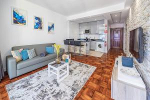 Una sala de estar con un sofá y un televisor. en Sea Breeze I, en Caniço