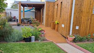 a wooden walkway in a garden with plants at La Kaz Héliconias in Le Tampon +2 photos