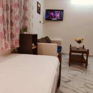 a bedroom with a bed and a tv on the wall at Ebenezer Stay in Trivandrum