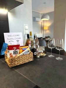Ein Korb mit Speisen und Wein stand mit Weingläsern auf einer Theke. in der Unterkunft Allure villa in Porto Rafti