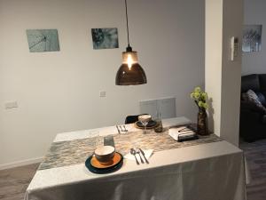 einen Tisch mit einem weißen Tischtuch mit zwei Tassen darauf in der Unterkunft Casa Blanca - Alameda in Toledo