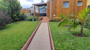 a garden with a walkway in front of a house at La Kaz Héliconias in Le Tampon