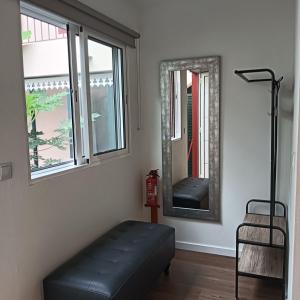 a living room with a bench and two mirrors at Maresia's House in Madalena do Mar