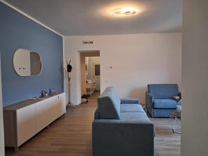 een woonkamer met een blauwe bank en een stoel bij Pontile 1 in Paratico