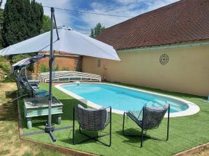 a swimming pool with two chairs and an umbrella at Maintenon Saint Martin de nigelles, maison d'hôtes Marguerite in Églancourt