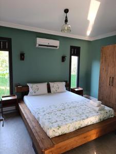 een slaapkamer met een groot bed met groene muren bij villakasel in Koycegiz