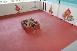 ein Raum mit rotem Boden und einer Feuerstelle in der Unterkunft SM Cottage in Mangaluru