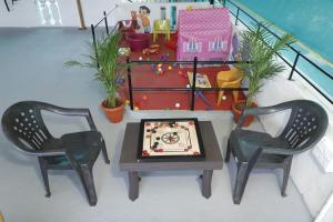 ein Tisch, zwei Stühle und ein Kuchen auf einem Tisch in der Unterkunft SM Cottage in Mangaluru