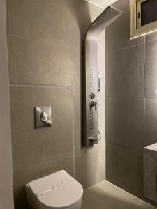 a bathroom with a toilet and a shower with a phone at شقق هذا منزلي فرع الربوة in Al Madinah