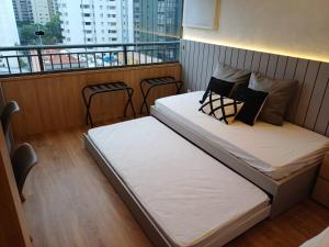 a bedroom with two beds on a balcony at Lindo e espaçoso studio com cama queen e cama solteiro in São Paulo