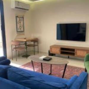 a living room with a blue couch and a tv at شقق هذا منزلي فرع الربوة in Al Madinah