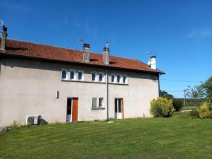 een groot wit huis met een grasveld ernaast bij Les mirabelliers 