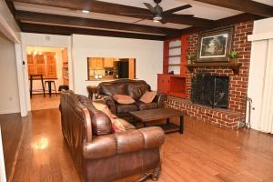 a living room with leather furniture and a fireplace at Mid-City Rustic Retreat in Baton Rouge